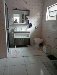 a bathroom with a sink and a toilet and a mirror at Quarto para Oktoberfest in Blumenau