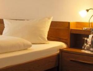 1 dormitorio con cama con almohada y mesita de noche en Moselstern Hotel Zum guten Onkel, en Bruttig-Fankel