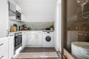 a white kitchen with a washing machine and a dishwasher at Ferienwohnung La Mer Olpenitz in Olpenitz
