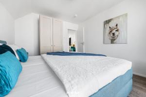 a bedroom with a large white bed with blue pillows at Ferienwohnung La Mer Olpenitz in Olpenitz