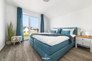 a bedroom with a blue bed and a window at Ferienwohnung La Mer Olpenitz in Olpenitz