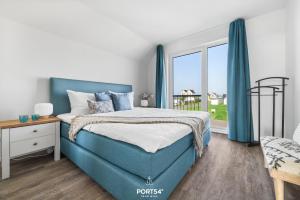 a bedroom with a blue bed and a window at Ferienwohnung La Mer Olpenitz in Olpenitz +22 photos