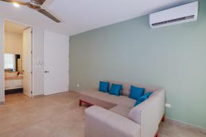 a living room with a couch and blue pillows at Sea Breeze By Fidalsa in Progreso
