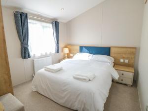 a bedroom with a large white bed with towels on it at 28 Finch in Scarborough