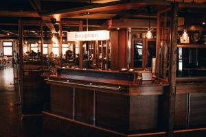 a bar in a restaurant with a sign that reads reception at Hotelli Puustelli Nivala in Nivala +9 photos