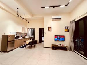 una cucina e un soggiorno con TV e tavolo di The Best Luxury suites Asia Spacious 3BR Sea View a Jelutong