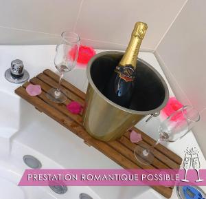 a bottle of champagne in a bucket on a bath tub at Le Cocon des Remparts-Romantique à Pierrefonds in Pierrefonds +22 photos