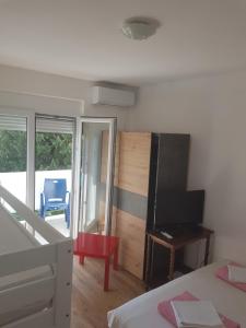 a bedroom with a bed and a flat screen tv at Apartmani Dream 3 in Šušanj