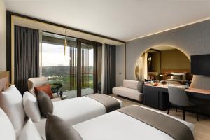 萨尔瓦尔Melea - The Health Concept - Adults Only Hotel的有两张床和一张书桌的酒店房间