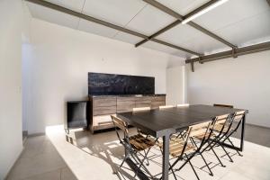 a dining room with a black table and chairs at Villa Kalma in Chiclana de la Frontera