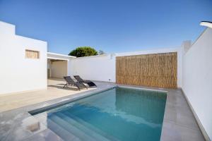 a swimming pool in the backyard of a house at Villa Kalma in Chiclana de la Frontera
