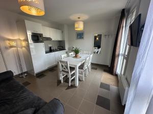 a kitchen and dining room with a white table and chairs at Appartement, château kergonano in Mériadec