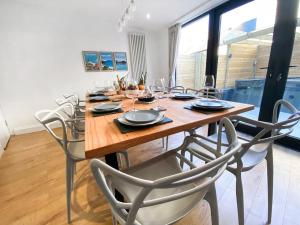 a dining room with a wooden table and chairs at Beautifully Presented 5 BR House with Hot Tub in Pwllheli