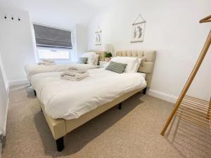 a bedroom with two beds and a window at Beautifully Presented 5 BR House with Hot Tub in Pwllheli