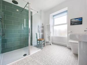 a bathroom with a shower and a toilet and a sink at Beautifully Presented 5 BR House with Hot Tub in Pwllheli