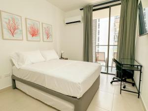 ein Schlafzimmer mit Bett, Schreibtisch und Fenster in der Unterkunft Apartamento Salinas del Mar - balcon y vista al mar - By Bedviajes in Playa Bello Horizonte