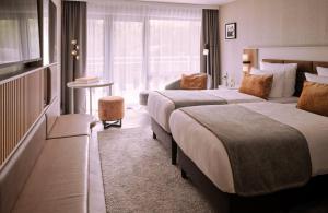 Una habitación de hotel con dos camas y una ventana. en Leonardo Royal Hotel Baden- Baden, en Baden-Baden