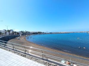 a beach with people swimming in the water at Deluxe Arguineguin Beach in Arguineguín +33 photos