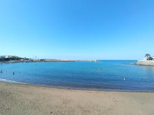 a beach with people swimming in the water at Deluxe Arguineguin Beach in Arguineguín