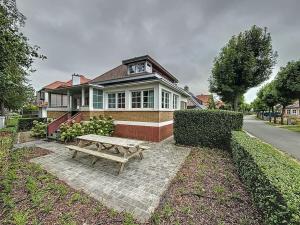 a wooden bench sitting in front of a house at Villa Horizon - Koksijde in Koksijde