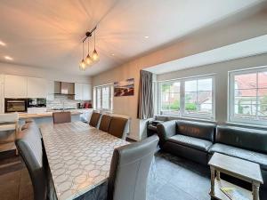 a living room with a table and a couch and a kitchen at Villa Horizon - Koksijde in Koksijde