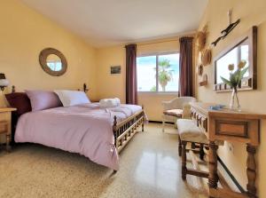 a bedroom with a bed and a desk and a window at Panorama Apartment in La Orotava