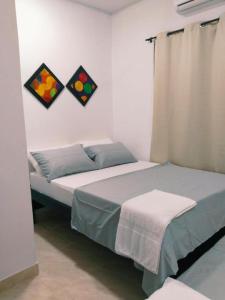 um quarto com uma cama e duas pinturas na parede em Apartamento Capri 1 em Puerto Triunfo