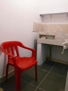 uma cadeira vermelha num quarto com uma secretária em Apartamento Capri 1 em Puerto Triunfo