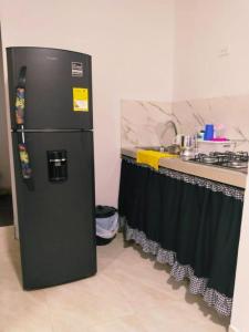 um frigorífico preto numa cozinha ao lado de um balcão em Apartamento Capri 1 em Puerto Triunfo