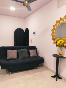 um sofá preto num quarto com um espelho em Apartamento Capri 1 em Puerto Triunfo