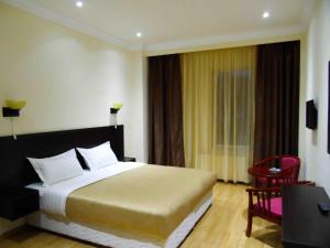 Habitación de hotel con cama y silla roja en Jermuk Ararat Health SPA, en Jermuk