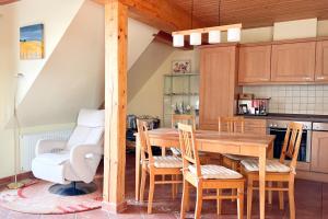 a kitchen with a wooden table and chairs at Ferienwohung 3 Sandorn in Kölpinsee