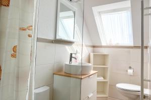 a bathroom with a sink and a toilet at Ferienwohung 3 Sandorn in Kölpinsee +7 photos