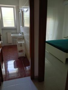 a bathroom with a bed and a sink and a mirror at Green54verde in Santo Spirito