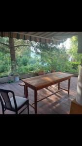 a wooden table and a chair on a patio at Kertből a hegyre Nyaralóház Mindszentkálla in Mindszentkálla