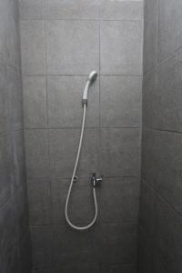 a shower with a hose in a shower stall at Apartemen Riverdale Cikarang by Alfa Rooms in Rawasuren