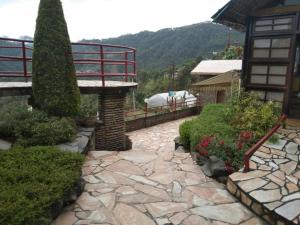 a garden with a stone walkway in front of a house at Resort Heritage Kausani in Kausani