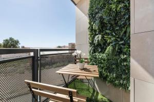 a balcony with a wooden table and a plant at Vivienda maiva in Alhama de Murcia