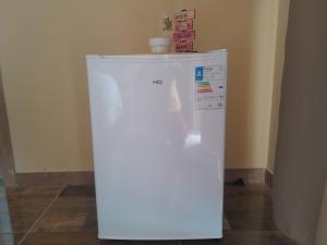 a white refrigerator freezer sitting in a room at Cabana Carambu 06 suíte in São Francisco do Sul