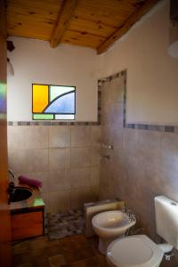 a bathroom with a toilet and a sink and a window at Hospedaje Sauce Linda - Casa Brea in Piedra Pintada