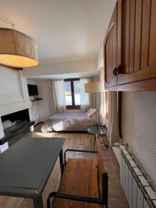 a small room with a bed and a table and a room with a bed gmaxwell at Las Rocas By Base 41 in San Carlos de Bariloche