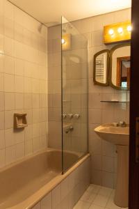 a bathroom with a bath tub and a sink at Las Rocas By Base 41 in San Carlos de Bariloche