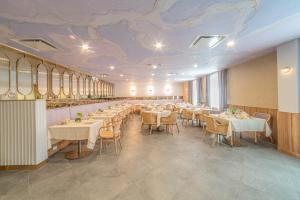 布鲁克林Iris Hotel Boston的一间带桌椅的餐厅以及一个带壁画的天花板
