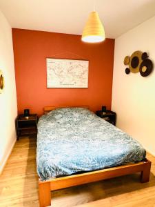 una camera da letto con un letto e due comodini di Bel appartement proche Parc & Lac a Rennes
