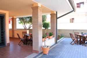 patio ze stołami, krzesłami i filarem w obiekcie SIGIS HOTEL - Fiumicino w mieście Fiumicino