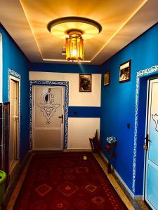 a blue room with a door and a chandelier at Hôtel Riad Atlas Dades in Boumalne