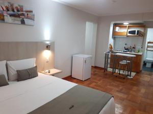 a bedroom with a large bed and a kitchen at ELDEPTO Parque Bustamante in Santiago