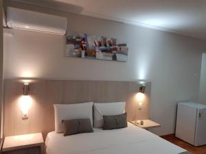 a bedroom with a white bed with two pillows at ELDEPTO Parque Bustamante in Santiago