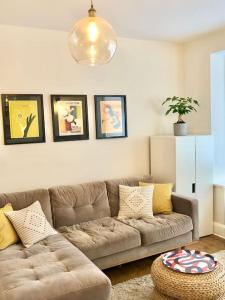 a living room with a brown couch in a room at Flat1Hove- renovated, 2BR, patio, beach, free onsite parking in Hove