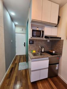 a small kitchen with a sink and a microwave at Studio ejecutivo in Achumani